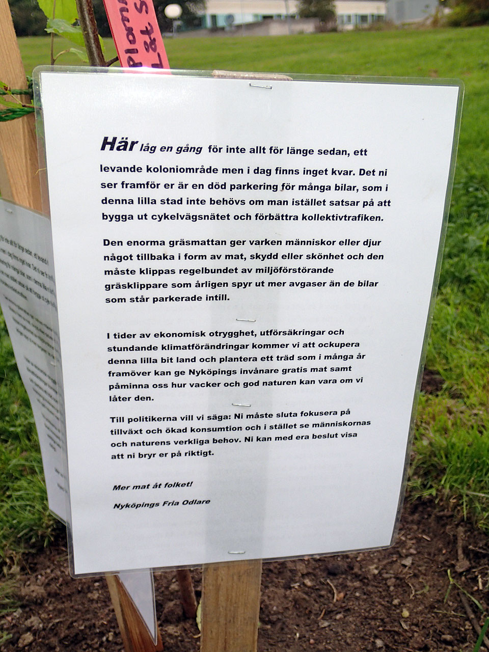 Bilden visar skyltens text, som avslutas med: Mer mat åt folket! Nyköpings Fria Odlare 