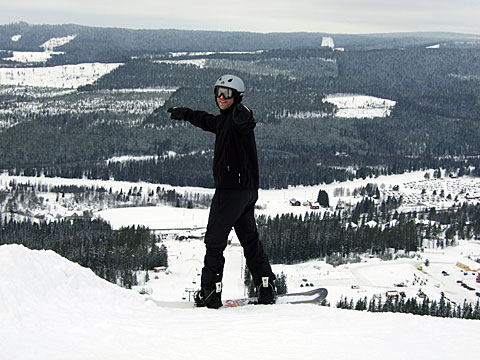 Bilden visar Hjalmar, som står på kanten till en pist och pekar både på fotografen och på pisten snett nedanför. 