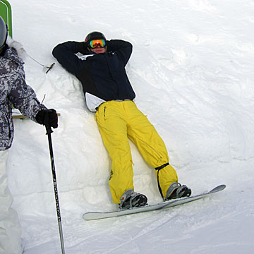 Bilden visar Tommy, som vilar mot en snövall men är startklar med brädan på. 