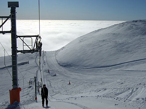 Bilden visar samma släplift, med Mikael närmast bakom. I bakgrunden syns dimman ovanifrån. 