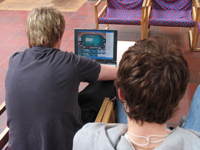 Bilden visar två juniorer, som spelar poker på nätet.