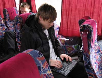 Bilden visar en junior, som sitter i bussen med en dator i knät.