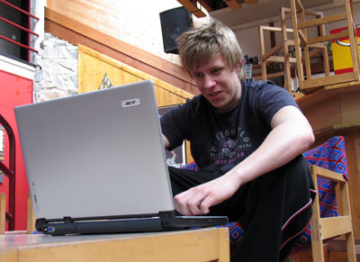 Bilden visar en junior, som sitter i vandrarhemmet och skriver på en dator.