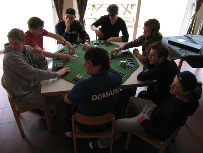Bilden visar några juniorer, som sitter runt ett av vandrarhemmets bord och spelar poker.